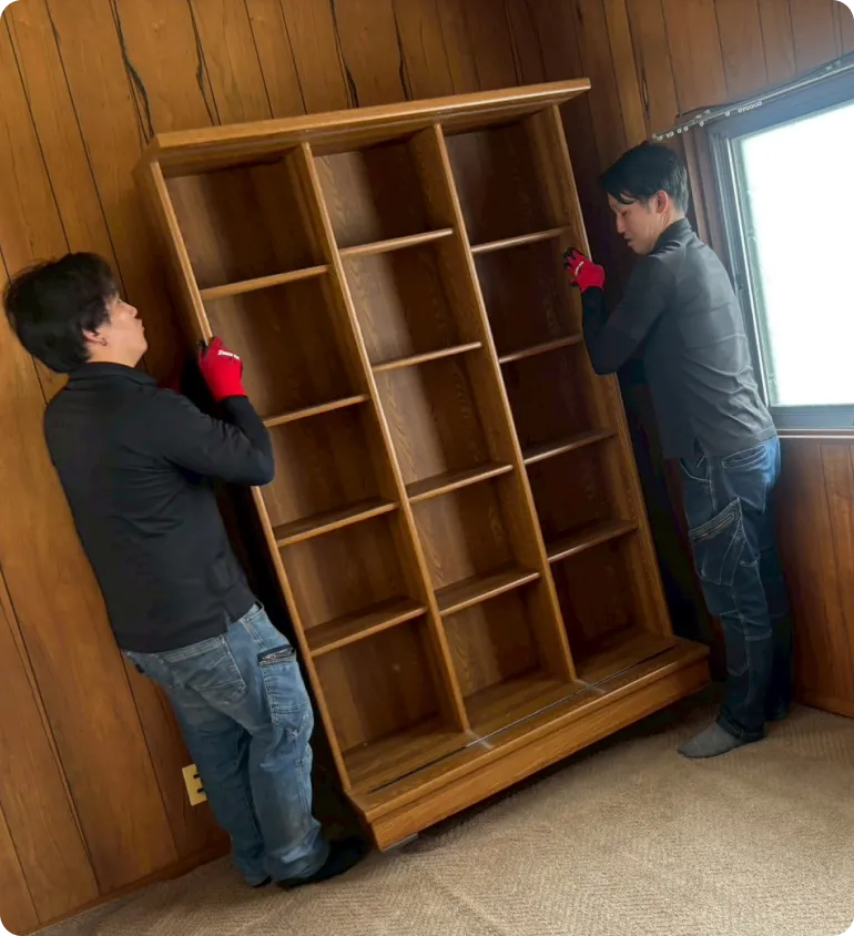 大型家具を二人で運び出すスタッフ